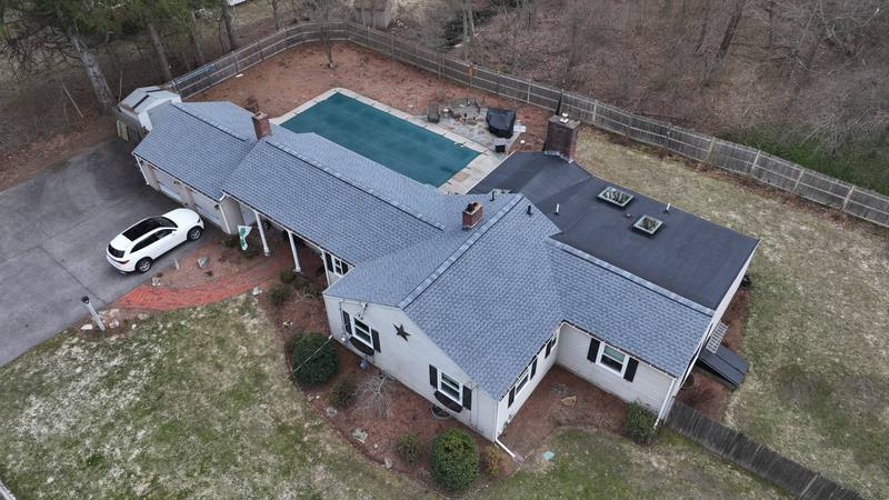 Ranch home with a blue-gray shingle roof, skylights and a pool