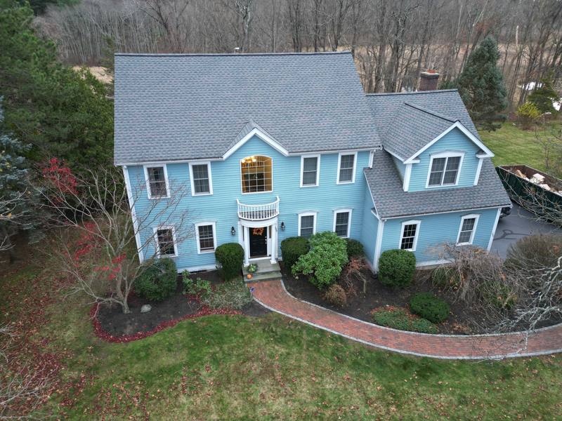 Blue clapboard colonial with a gray shingle roof