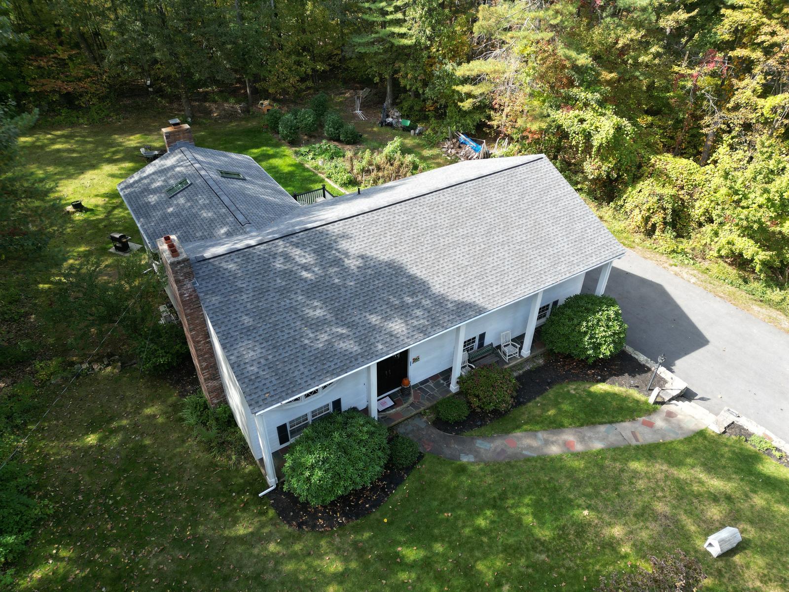 Cape with a gray shingle roof, skylights and white gutters