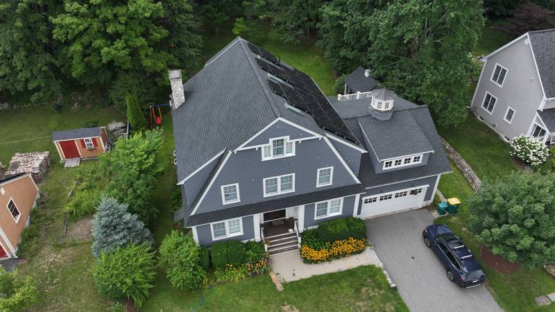 Gray shingle-sided home with a dark roof and solar panels