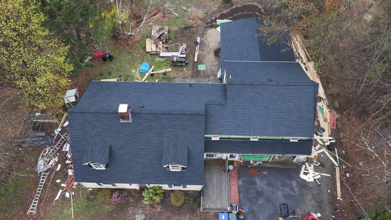 Roof replacement in progress on a cape with dormers