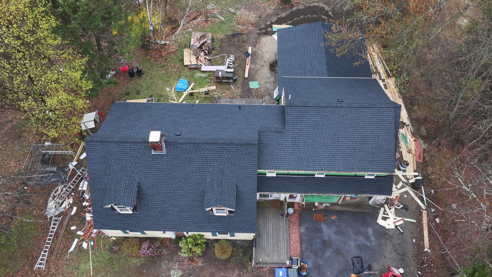 Roof replacement in progress on a cape with dormers