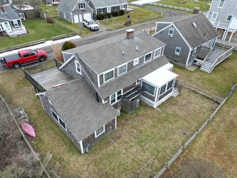 Cedar-shingled cape with a gray asphalt shingle roof